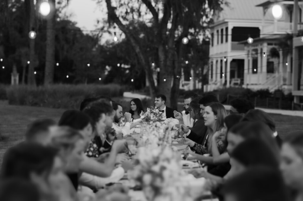 A bride and groom host their reception dinner at sunset on Crane Island in Amelia Island, FL captured by Tags Photography, an Amelia Island Wedding Photographer.